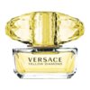 Flakon perfum o nazwie "Versace Yellow Diamond" z przezroczystego szkła, wypełniony żółtym płynem, z ozdobnym, żółtym korkiem przypominającym diament. Na flakonie widoczny jest napis: "VERSACE YELLOW DIAMOND".