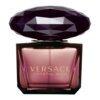 Kwadratowy flakon perfum z ciemnym, fasetowanym korkiem, na którym widnieje złoty napis "VERSACE CRYSTAL NOIR". Flakon ma ciemnoróżowy odcień, a korek przypomina oszlifowany kamień.
