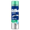 Puszka żelu do golenia z napisem "Gillette Series" na niebieskim tle, z zielonymi i białymi paskami oraz tekstem "Shave Gel", "Soothing with Aloe Vera", "Sensitive". Na górze znajduje się przezroczysta, zielona nakrętka.