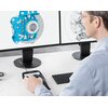 Na zdjęciu widać osobę obsługującą manipulator 3D przed dwoma monitorami, na których wyświetlane są modele techniczne. Na manipulatorze widoczne jest logo "3Dconnexion".