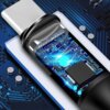 Zbliżenie na wtyczkę kabla USB-C, której obudowa jest przezroczysta, ukazując wewnętrzne elementy elektroniczne z niebieskim podświetleniem. W tle widoczna jest powierzchnia przypominająca płytkę drukowaną z niebieskimi ścieżkami i srebrnymi elementami.