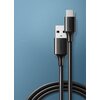Na zdjęciu widoczny jest czarny kabel USB - USB-C o długości 0,5 metra, z logo "UGREEN" na obu końcówkach. Kabel leży na niebieskim tle, a jego przewód jest częściowo zwinięty.