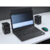 Na zdjęciu znajduje się laptop z filtrem prywatyzującym na ekranie, na którym widoczny jest arkusz kalkulacyjny. Obok laptopa znajdują się dwa głośniki oraz zielona myszka komputerowa.