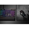 Na zdjęciu widoczna jest klawiatura z podświetleniem RGB oraz mysz komputerowa na podkładce. Na klawiaturze znajduje się logo "CORSAIR", a mysz ma podświetlone logo w kształcie żagla.