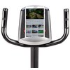 Na zdjęciu widoczny jest panel sterowania roweru magnetycznego z zamontowanym tabletem marki Samsung, na którym wyświetlana jest strona z filmami wideo. Kierownica roweru ma ergonomiczne uchwyty z wbudowanymi czujnikami.