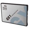 Na zdjęciu widoczny jest dysk SSD z napisem "TEAM GROUP GX1 Solid State Drive" na srebrnej obudowie. W tle znajduje się duża, stylizowana litera "G" w jasnoniebieskim kolorze.