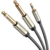 Na zdjęciu widoczny jest kabel z trzema wtykami: dwa większe Jack 6.35 mm z oznaczeniami kolorystycznymi (czerwonym i białym) oraz jeden mniejszy TRS 3.5 mm. Na metalowych obudowach wtyków widnieje logo "UGREEN", a przewody są oplecione materiałem w kolor