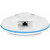 Na zdjęciu znajduje się biały, okrągły punkt dostępu z niebieskim paskiem, posiadający port Ethernet oznaczony jako "PoE IN" oraz przycisk "RESET". Widoczne są również symbole certyfikacji i kod QR na etykiecie umieszczonej poniżej portu.