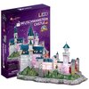 Pudełko produktu przedstawia kolorowy model zamku Neuschwanstein z napisem "NEUSCHWANSTEIN CASTLE" oraz logo "CubicFun" i "LED". Obok pudełka znajduje się złożony model zamku z widocznymi elementami oświetlenia LED, umieszczony na podstawie imitującej kra