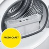 Otwarty bęben suszarki z widocznym filtrem na tle metalowego wnętrza. Na żółtym okręgu znajduje się napis "FRESH-CARE™".