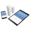 Na zdjęciu znajduje się zestaw inteligentnej stacji pogodowej NETATMO, składający się z dwóch cylindrycznych modułów oraz smartfona i tabletu wyświetlających aplikację pogodową. Na ekranach widoczne są dane pogodowe, takie jak temperatura 21°C i 23°C, ora