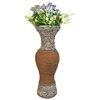 Waza ogrodowa SASKA GARDEN o wymiarach 23.5 x 23 x 63.5 cm, wykonana z materiału imitującego kamień i drewno, z bukietem sztucznych kwiatów w odcieniach fioletu, bieli i zieleni.