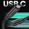 Czarny kabel USB-C - USB-C z logo "UGREEN" na obu końcówkach, na tle napisu "USB C" oraz dynamicznych, kolorowych linii.