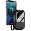 Na zdjęciu znajduje się czarny powerbank z wyświetlaczem pokazującym liczbę "99" oraz oznaczeniem "20W" na obudowie, obok którego widoczny jest smartfon z ekranem pokazującym godzinę 3:49 i poziom naładowania baterii 80%. Powerbank jest połączony z telefo