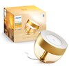 Złota lampa biurkowa z białym wnętrzem i przezroczystą podstawą jest przedstawiona obok pudełka z napisem "PHILIPS hue White and color ambiance Special Edition". Na pudełku widoczne są ikony Bluetooth i kompatybilności z aplikacjami mobilnymi.