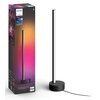 Na zdjęciu znajduje się czarna lampa stołowa o smukłej konstrukcji oraz jej opakowanie z kolorowym gradientem i logo PHILIPS. Na opakowaniu widnieje napis: "hue White and color ambiance Gradient Signe Table lamp" oraz "Personalise your home with smart lig
