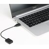 Na zdjęciu widoczny jest laptop z napisem "MagicBook" nad ekranem, do którego podłączony jest czarny adapter audio z dwoma wejściami jack 3.5 mm i wtykiem USB-A. Adapter leży na białej powierzchni obok laptopa.