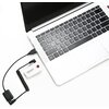 Na zdjęciu widoczny jest laptop z klawiaturą i touchpadem, do którego podłączony jest biały adapter audio z napisem "Saramonic" oraz przyciskiem z czerwoną literą "G". Adapter jest połączony spiralnym kablem z czarnym elementem.