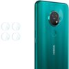 Na zdjęciu widoczny jest zielony telefon Nokia z okrągłym modułem aparatu, na którym umieszczono szkło ochronne z napisem "ZEISS". Obok telefonu znajdują się cztery okrągłe szkła ochronne na obiektyw.