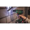 Na zdjęciu widoczna jest zielona wiertarko-wkrętarka marki BOSCH z napisem "EasyDrill 18V-40", trzymana w dłoni, używana do wiercenia w ścianie z cegieł. Na akumulatorze znajduje się logo "All 18V" oraz napis "ALLIANCE".