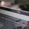 Na zdjęciu widoczny jest ekran laptopa z zaślepką kamery oznaczoną logo "Savio". Na ekranie wyświetlana jest strona internetowa z widocznymi kategoriami, takimi jak "Kable i adaptery" oraz "Do samochodu".