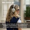 Na zdjęciu widoczne są słuchawki nauszne na osobie, z tekstem "WH-1000X M5" w górnej części oraz opisem: "Zanurz się w luksusie dzięki wygodnym, miękkim nausznikom, regulowanemu pałąkowi i ergonomicznej konstrukcji." w dolnej części. W tle znajduje się ro