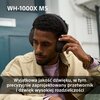 Na zdjęciu widoczne są słuchawki nauszne na osobie, z tekstem "WH-1000X M5" u góry oraz napisem na dole: "Wyjątkowa jakość dźwięku, w tym precyzyjnie zaprojektowany przetwornik i dźwięk wysokiej rozdzielczości".