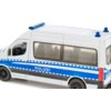 Model samochodu policyjnego w kolorze białym z niebieskimi pasami i napisem "POLIZEI" na boku. Pojazd ma przezroczyste okna, niebieskie światła na dachu i czarne koła.