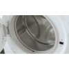 Zdjęcie przedstawia wnętrze bębna pralki z widocznymi otworami wentylacyjnymi i metaliczną powierzchnią. Drzwi pralki są otwarte, ukazując zawiasy i uszczelkę.