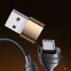 Czarny kabel USB z końcówkami USB i USB-C, z widocznym napisem "USAMS" na jednej z wtyczek. Kabel ma plecioną osłonę, a tło jest ciemne z delikatnymi pomarańczowymi akcentami.