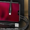Na zdjęciu znajduje się czerwony, pleciony kabel USB-Micro USB marki USAMS, podłączony do smartfona z czerwonym ekranem. Na dole widoczny jest napis: "Trwały i elastyczny kabel".