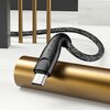 Pleciony kabel USB - Micro USB w kolorze czerwonym, o długości 1 metra, z widocznym logo "USAMS" na czarnym złączu, leży na złotym cylindrze. W tle znajdują się elementy dekoracyjne w kolorze złotym i czarnym.