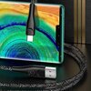 Na zdjęciu widoczny jest pleciony kabel USB-USB-C w kolorze czerwonym, podłączony do smartfona z kolorowym wyświetlaczem. Na wtyczce USB-C znajduje się napis "USAMS", a na wtyczce USB widoczne jest logo producenta.