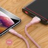 Różowy kabel USB-Lightning marki USAMS U33 o długości 1,2 m jest podłączony do smartfona i powerbanku, leżących na drewnianej powierzchni. Na kablu widoczne jest logo "USAMS", a obok znajduje się okrągły symbol z napisem "Pink".