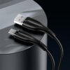 Czarny kabel USB - USB-C o długości 1 metra leży na metalowej powierzchni, z widocznymi złączami USB i USB-C. Na obu końcówkach kabla znajduje się napis "USAMS".