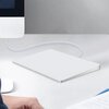 Na zdjęciu znajduje się touchpad o prostokątnym kształcie, podłączony kablem do komputera stacjonarnego. Na biurku widoczny jest również fragment dokumentu z tekstem.