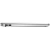 Srebrny laptop z zamkniętą pokrywą, widoczny z boku, z dwoma portami USB i gniazdem zasilania. Obudowa ma smukły profil i minimalistyczny design.