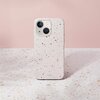 Na zdjęciu widać osobę siedzącą na drewnianej ławce w parku, trzymającą telefon w etui o piaskowym kolorze z wzorem terrazzo. W tle znajduje się zielona roślinność.