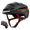Czarny kask rowerowy z czerwonymi paskami i wbudowaną lampką, z widocznym napisem "LIVALL REDEFINE YOUR SAFETY" oraz cyfrą "7". Obok kasku znajduje się czarny przycisk z czerwonym środkiem.