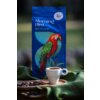 Na zdjęciu znajduje się opakowanie kawy ziarnistej "Morning Bird Medium" z kolorową grafiką papugi na niebieskim tle oraz filiżanka kawy na drewnianej tacy z ziarnami kawy, umieszczona na zielonym materiale. Na opakowaniu widoczny jest napis "Rzemieślnicz