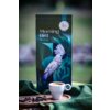 Na zdjęciu znajduje się opakowanie kawy ziarnistej "Morning Bird Mild" z ilustracją ptaka na tle liści, obok filiżanki espresso i rozsypanych ziaren kawy na drewnianej tacy. Na opakowaniu widoczna jest pieczęć z napisem "Rzemieślnicza".
