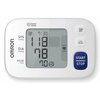 Na zdjęciu znajduje się ciśnieniomierz z wyświetlaczem pokazującym wartości: SYS 118 mmHg, DIA 78 mmHg, PULSE 70/min oraz czas 7:30. Widoczne są przyciski z ikonami oraz napis "OMRON" i "START/STOP".