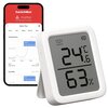 Na zdjęciu znajduje się biały termometr z wyświetlaczem pokazującym temperaturę 24,6°C oraz wilgotność 63%. W tle widoczny jest smartfon z aplikacją, na której ekranie widać wykresy temperatury i wilgotności oraz teksty: "SwitchBot", "matter", "SwitchBot 