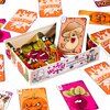 Na zdjęciu znajduje się otwarte pudełko z kartami do gry, ozdobione kolorowymi ilustracjami warzyw i grzybów. Na pudełku widnieje napis: "WIRUS! Najbardziej zaraźliwa gra karciana na świecie", a wokół rozłożone są karty z różnymi postaciami i napisami, ta
