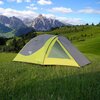 Zielono-szary namiot stoi na trawiastej polanie z widokiem na górskie szczyty w tle. Na namiocie widoczne są napisy: "NILS CAMP" oraz "DISCOVERY".