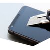 Na zdjęciu widać smartfon z nałożonym szkłem hartowanym, na którym leży metalowy klucz. Szkło jest gładkie i błyszczące, a klucz wskazuje na jego odporność na zarysowania.