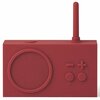 Czerwony radioodtwarzacz z widocznym głośnikiem, anteną oraz przyciskami oznaczonymi symbolami minus, plus, Bluetooth i FM. Urządzenie ma prostokątny kształt i minimalistyczny design.