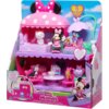 Na zdjęciu znajduje się zestaw figurek z motywem Myszki Minnie w różowym domku z białymi kropkami, zawierający różne postacie i akcesoria. Na opakowaniu widnieje napis: "Disney Junior Minnie Bow Home Playset" oraz informacja o 13 elementach w zestawie.