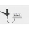 Na zdjęciu widoczny jest czarny mikrofon podłączony kablem do srebrnego urządzenia audio z kilkoma pokrętłami i gniazdami. Kabel to "UGREEN AV130 XLR męski - XLR żeński 3 m Czarny".