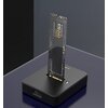 Na zdjęciu znajduje się stacja dokująca do dysków z włożonym pionowo dyskiem SSD, na którym widoczny jest napis "V-NAND SSD 970 EVO NVMe M.2". Stacja dokująca ma prostokątny kształt i ciemny kolor, z widocznym przyciskiem i portem.
